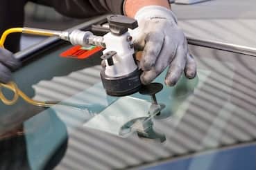 Man fixing a stone chip in windshield